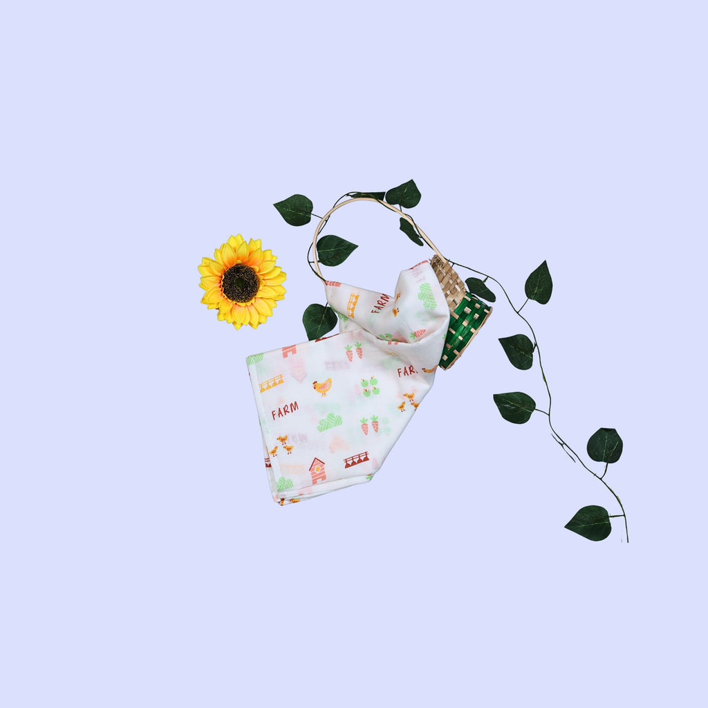 Farm Tales Baby Swaddle in white printed with farm-themed pattern