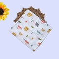 Little Wheels Baby Swaddle in white printed with rainbow and playful vehicles themed pattern