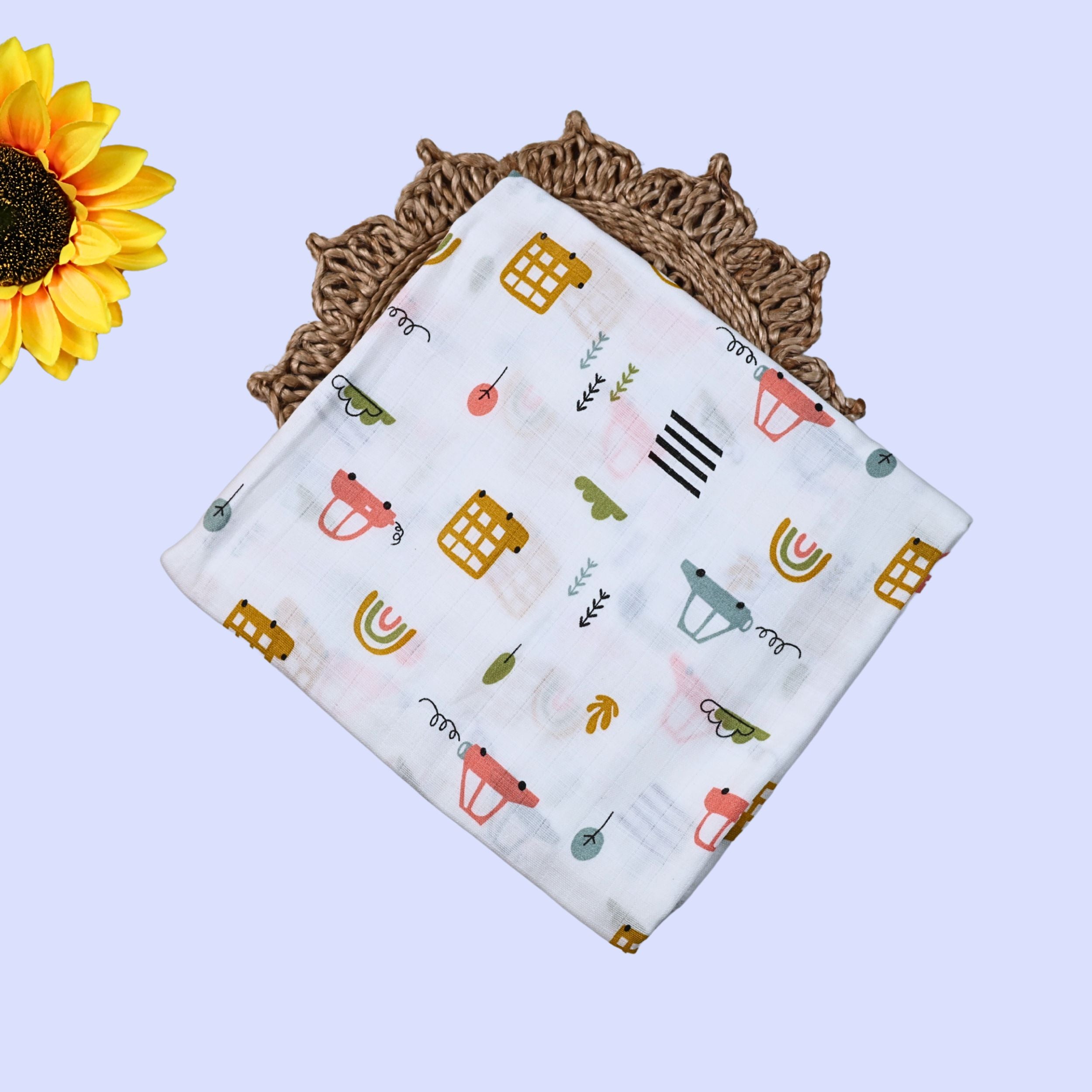 Little Wheels Baby Swaddle in white printed with rainbow and playful vehicles themed pattern