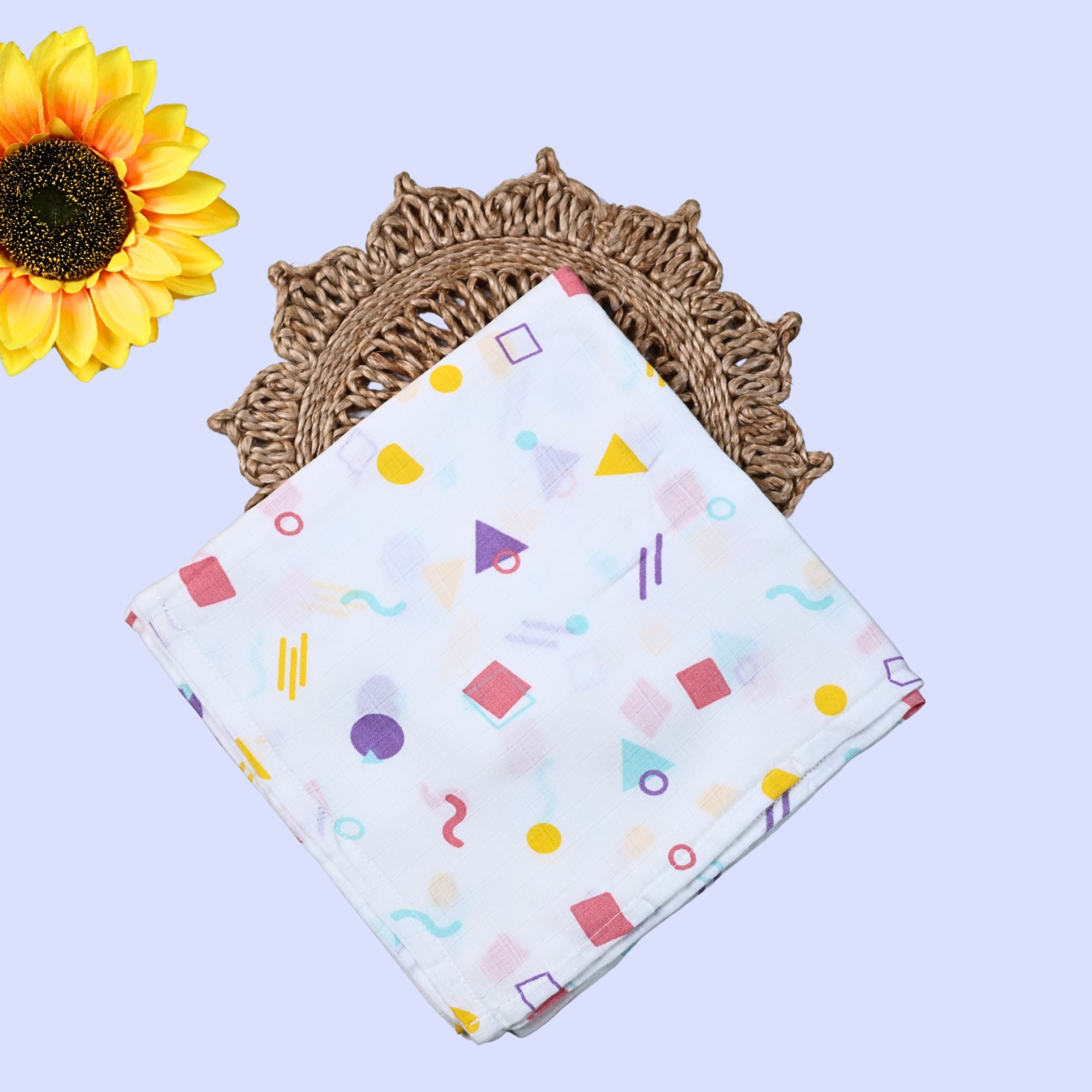 Shape Pops Baby Swaddle in white printed with colorful geometric patterns
