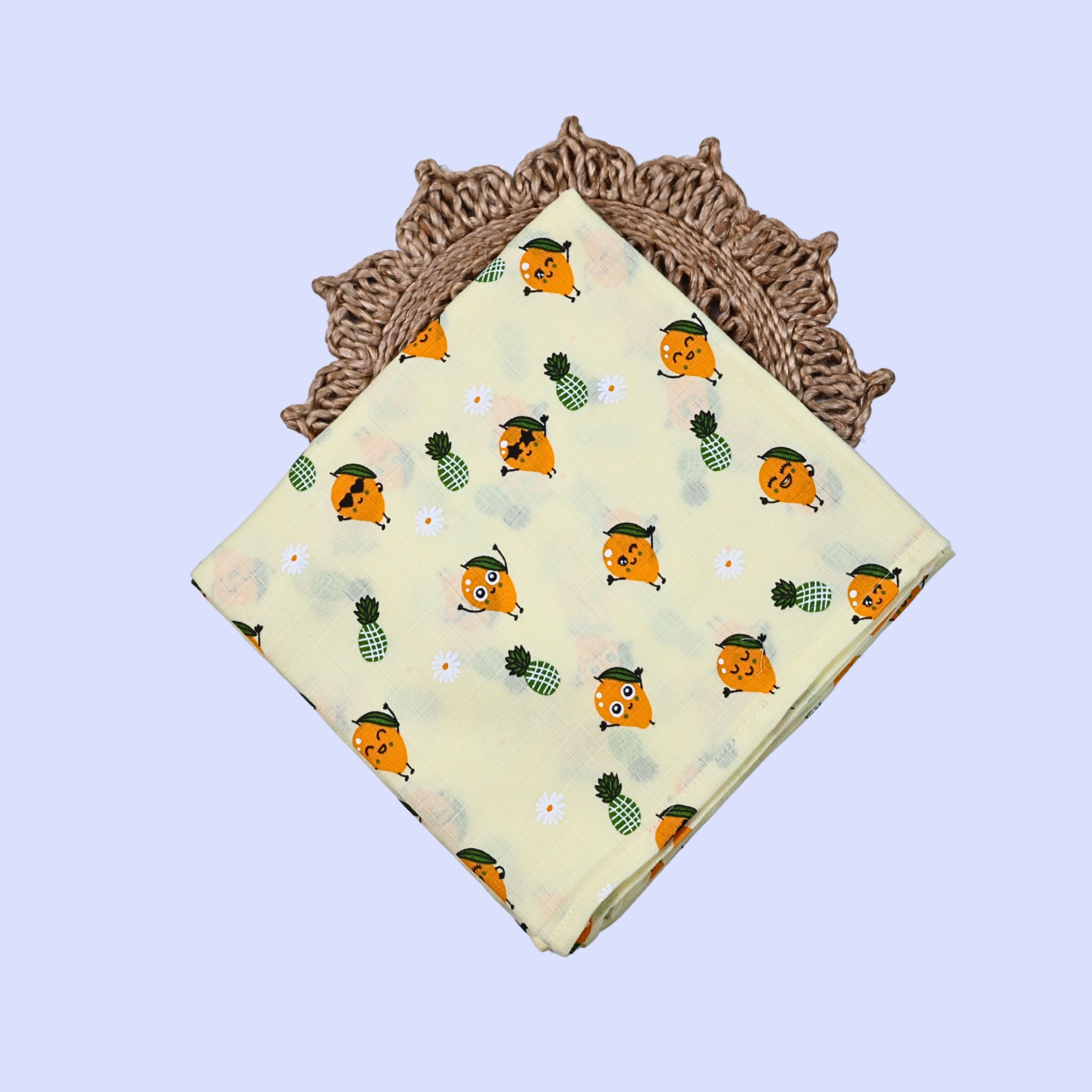 Tropi Treats Baby Swaddle in pastel yellow fabric printed with mango and pineapple patterns