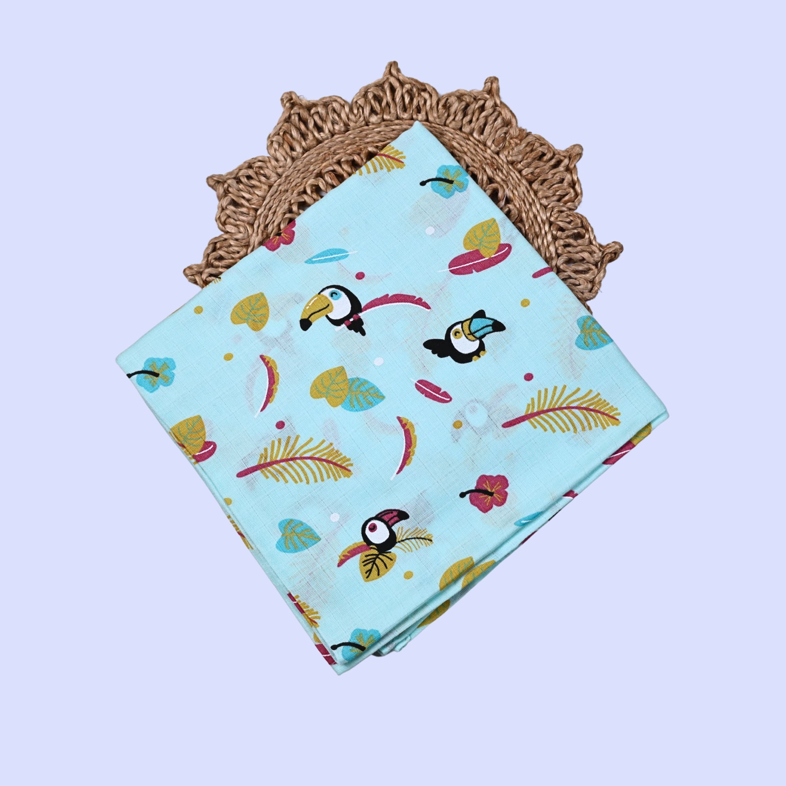 Tropical Toucans Baby Swaddle in turquoise blue printed with toucan and leaf pattern.