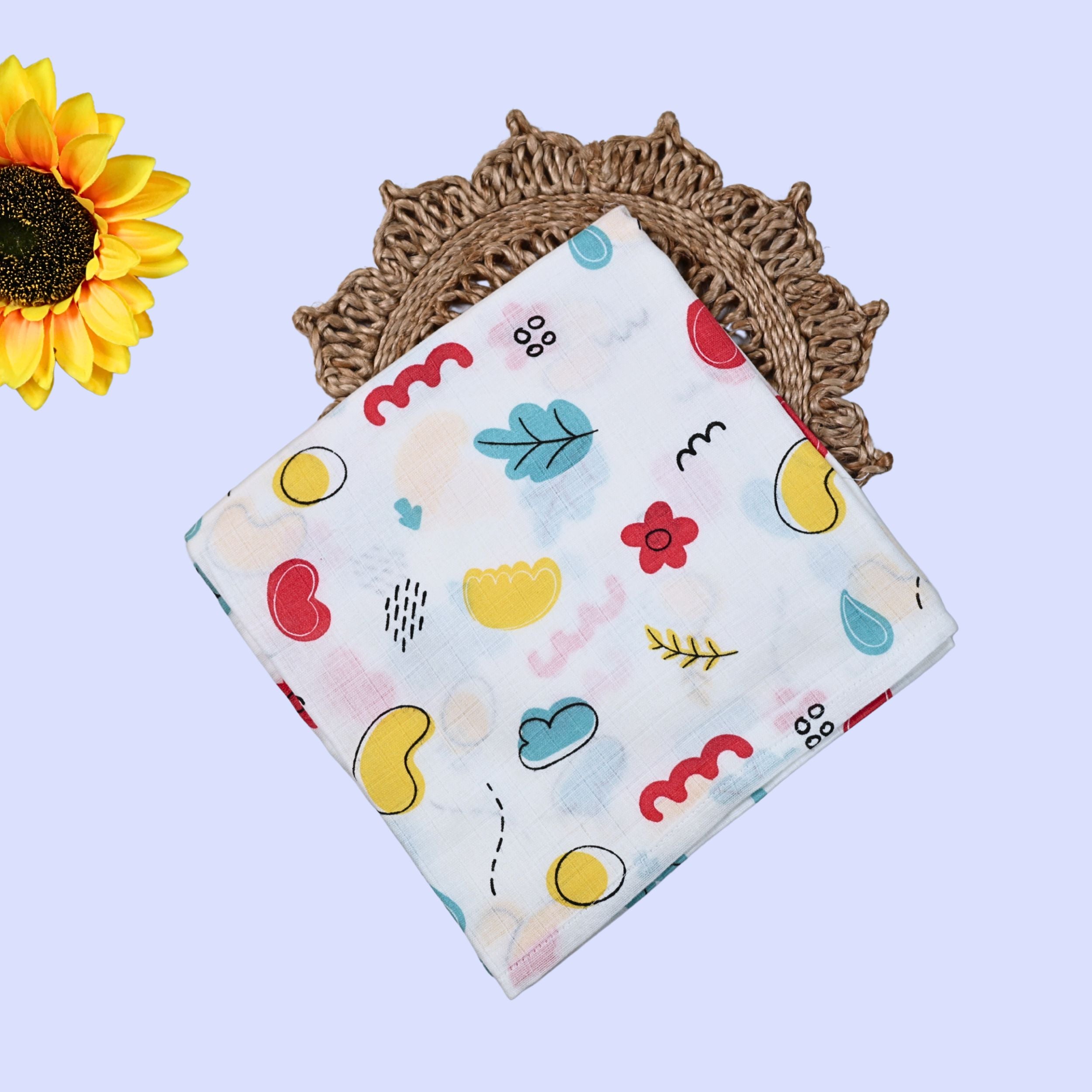 Wild Doodles Baby Swaddle in white printed with yellow, red and pastel green scribble patterns.