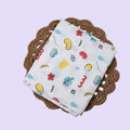 Wild Doodles Baby Thottil (Jhula) in white with mosquito net, printed with yellow, red and pastel green scribble patterns.
