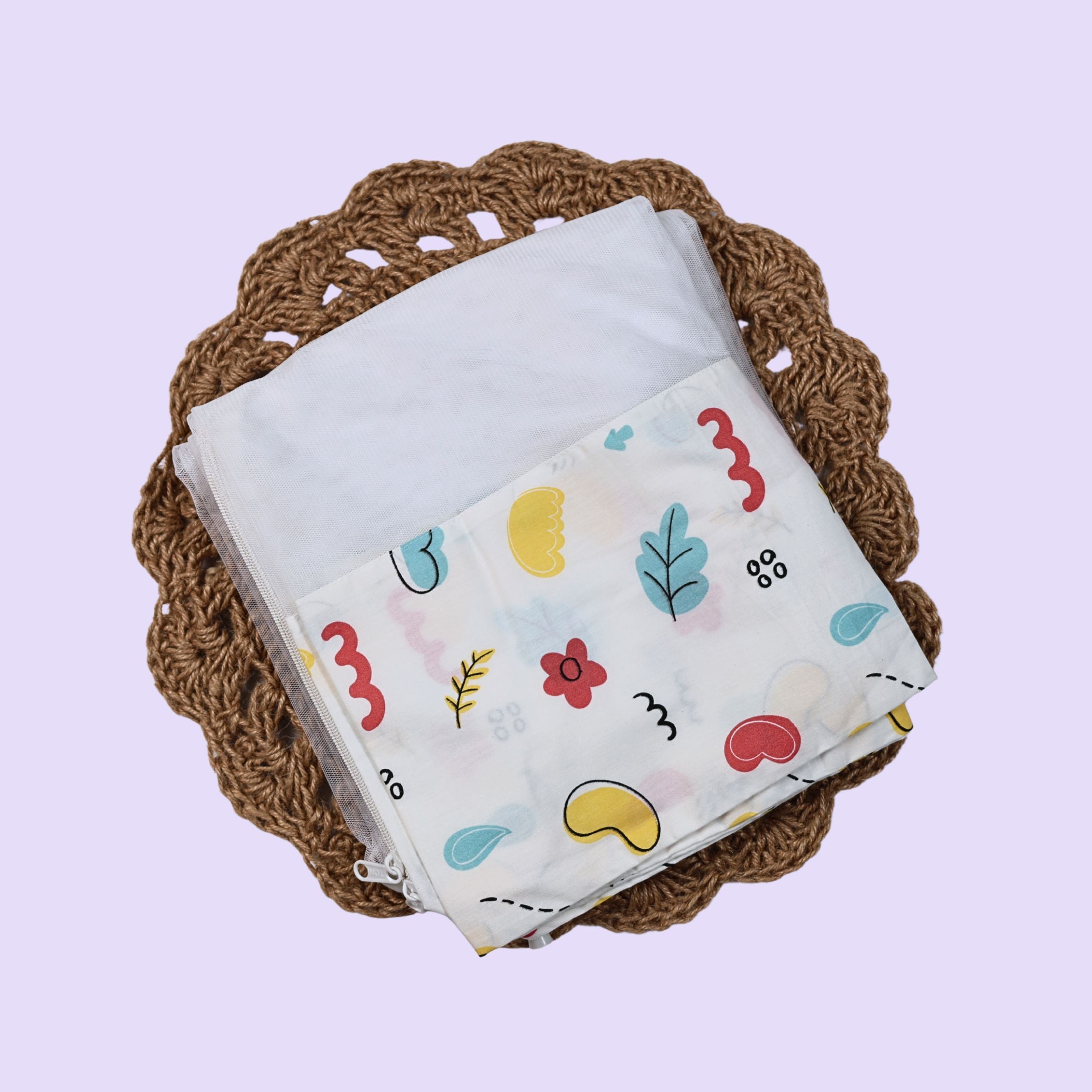 Wild Doodles Baby Thottil (Jhula) in white with mosquito net, printed with yellow, red and pastel green scribble patterns.